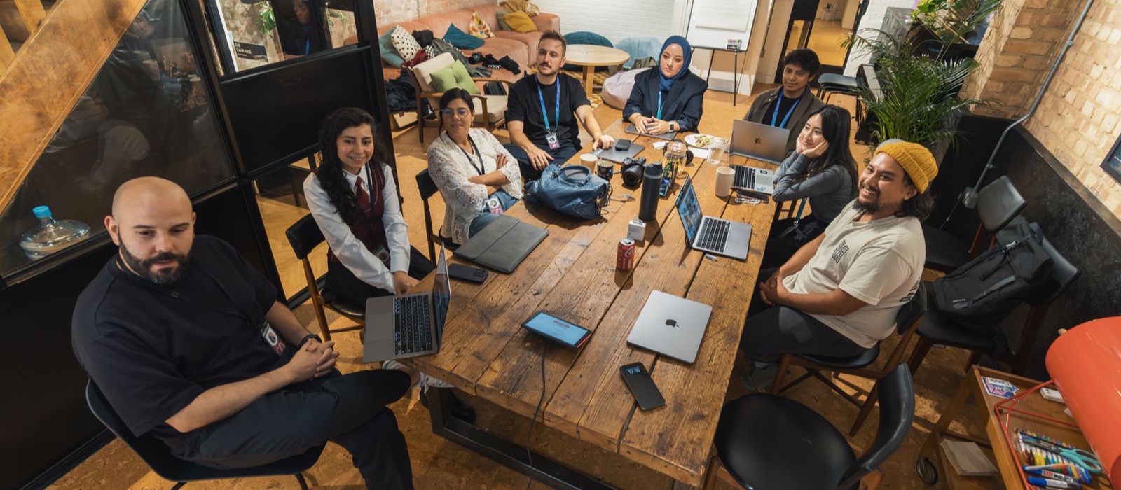 Small team collaborating around laptops in a modern office, representing the accountable Miniteq team